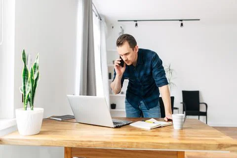 Young man working from home using laptop. Stock Photos