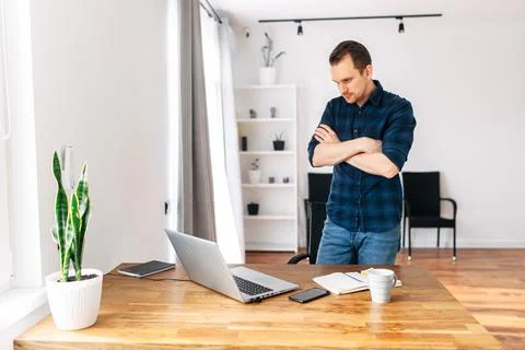 Young man working from home using laptop. Stock Photos