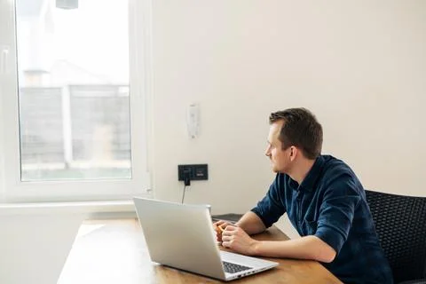 Young man working from home using laptop. Stock Photos