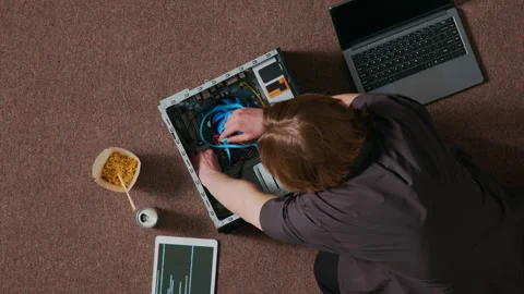 Young Man Working on Internal Components of Desktop Computer on Carpeted Floor Stock Footage 312448654