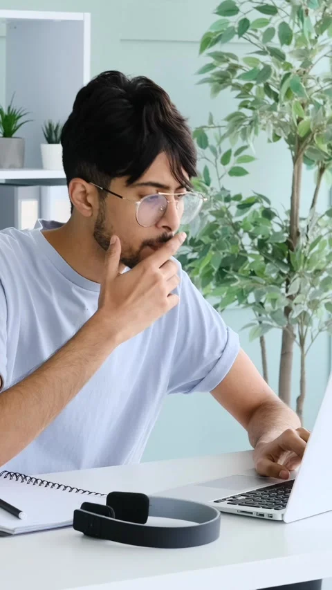 Young Man Working on Laptop and Taking Notes in Home Office Stock Footage 328129164