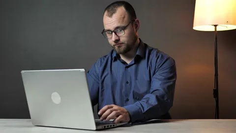 Young man working on laptop computer at home office finishing typing and closing Stock Footage 238481667