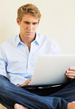 Young man working on laptop computer at home Stock Photos