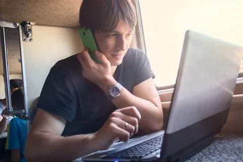 Young man working on laptop computer on the train Stock Photos