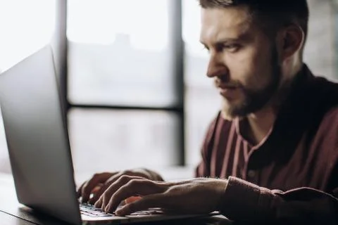 Young man working on laptop computer at home, freelancing concept Stock Photos