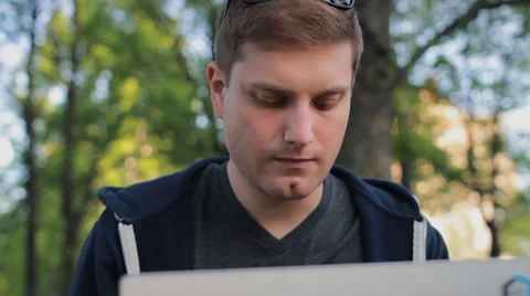 Young man working on laptop in the park Video stock 64480984
