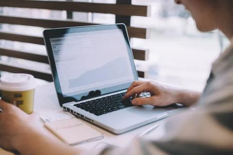 Young man working on a macbook or laptop in cafe Foto stock