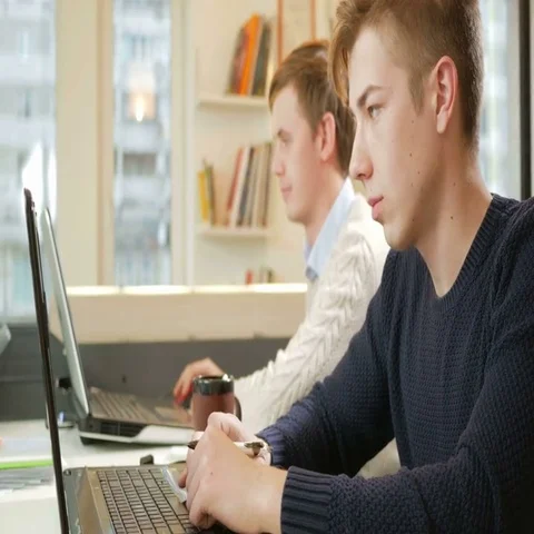 Young man working in the office of the laptops on the project. Focused typing on Stock Footage 69528283