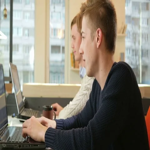 Young man working in the office of the laptops on the project and begin to laugh Stock Footage 69528327