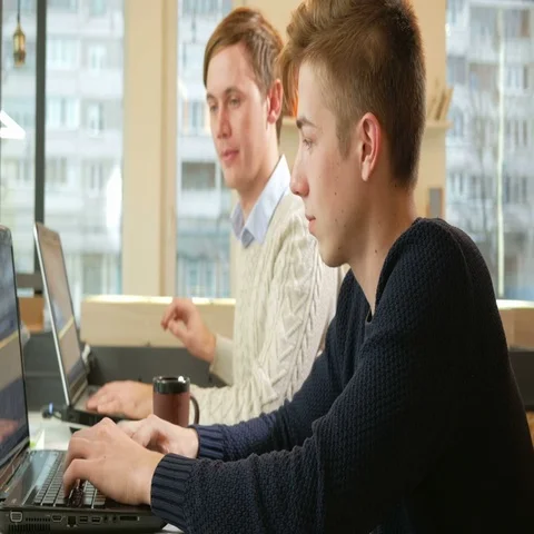 Young man working in the office of the laptops on the project. They confer on an Stock Footage 69528689