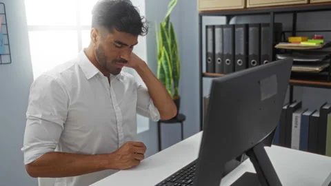 Young man working in an office typing on a keyboard and stretching his neck.. Stock Footage 289264033