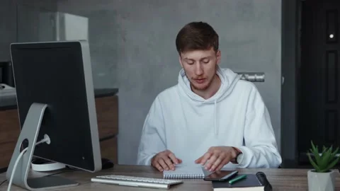 Young man working online from home, answering phone call. Self isolation Stock Footage 151995115