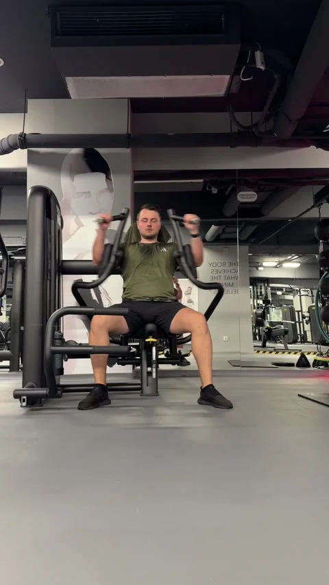 Young man working out on a chest press machine, training his upper body strength Stock-Footage 339601249