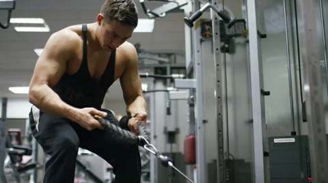 Young man working out in the gym, pulling weights with rope handles Stock-Footage 59886961