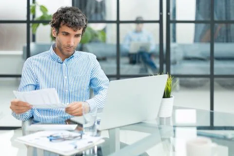Young man is working with papers while sitting in the office. Successful entr Foto stock