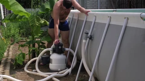 Young man working with a pool filtration system Stock Footage 156194692