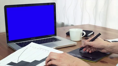 Young man working with printed analyzing graphs using digital tablet and laptop Video stock 81879590