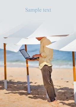Young man working remotely under the umbrella Stock Photos