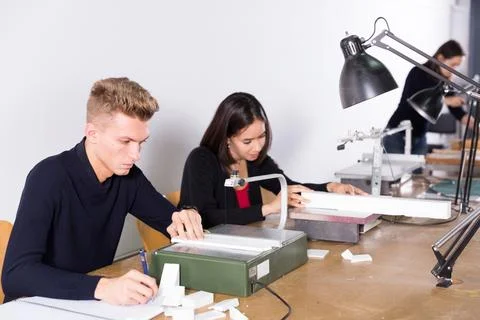 Young man working on scroll saw in architecture modeling workshop 스톡 사진