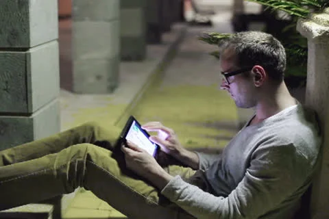 Young man working with tablet computer at night garden Video stock 24960319