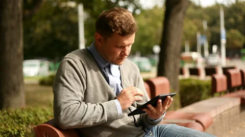 Young man working on tablet computer in city park, 1080p Stock Footage 28505065