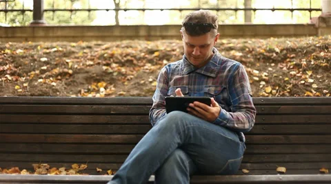 Young man working on tablet computer in city park, 1080p Stock Footage 28508403
