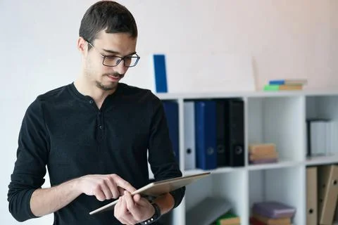 Young man working with tablet, receiving video call, talking with partners Stock Photos