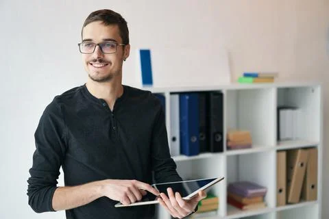 Young man working with tablet, receiving video call, talking with partners Stock Photos