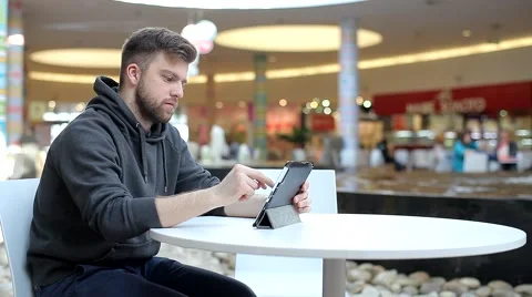Young Man Working on a Tablet in Shopping Center. Video stock 47977292