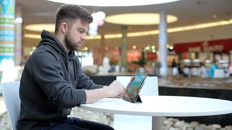 Young Man Working on a Tablet in Shopping Center. Stock Footage 47977294