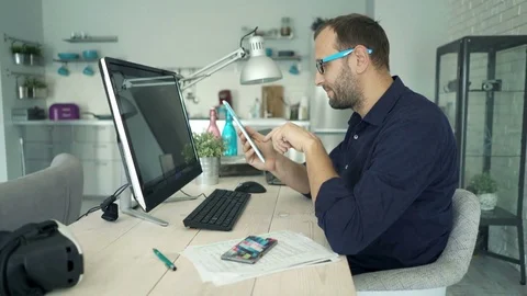 Young man working with tablet sitting by tablet at home Stock Footage 74978481