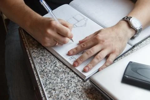 Young man working on the train, write in a large notebook with copy space Stock Photos