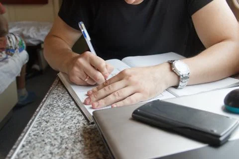 Young man working on the train, write in a large notebook with copy space Stock Photos