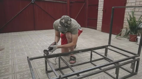 Young man in working uniform holding a drill in his hands Vidéo 145182171