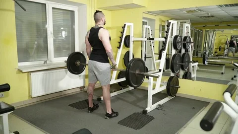 Young man workout with dumb-bell in the gym view from back Stock Footage 74134703