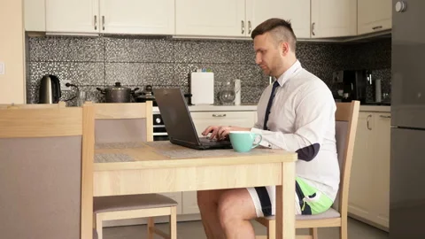 Young man works at the computer at home because of the quarantine. Little Stock Footage 129693717