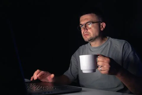 Young man works at the computer at night. Stock Photos