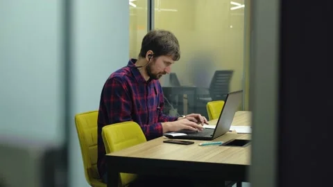 Young man works with headphones at the computer in the office. Stock Footage 147454436