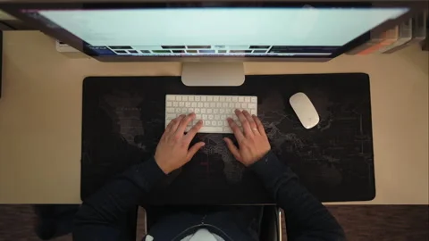 A young man works at home on a computer and looks at the display, types on the Stock Footage 150882724