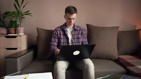 A young man works from home on a computer. quarantine, isolation. cozy room Stock Footage 212610708