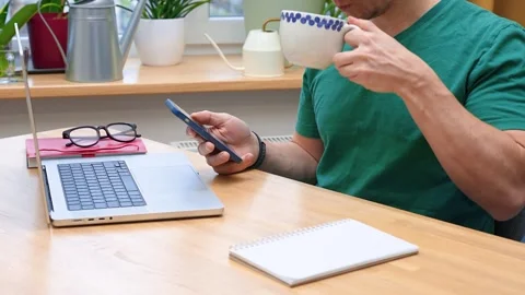A young man works from home in the kitchen using a laptop. Freelancer worki.. Stock Footage 321116081