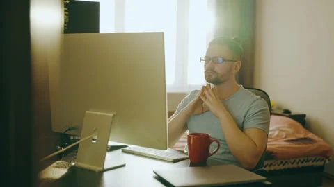 A young man works at home using a desktop computer, thinking about the task. Stock Footage 239445253