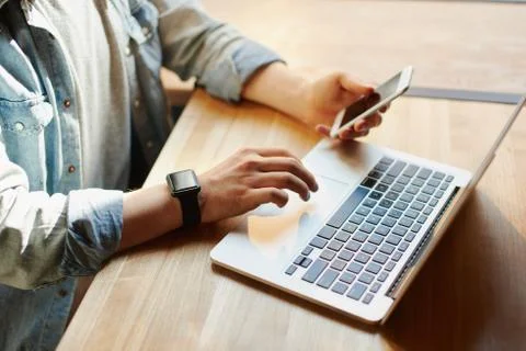 Young man works on the laptop in the cafe. Stock Photos