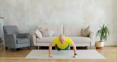 A young man works out doing push-ups on his fists at home. Front view. Stock Footage 152782255