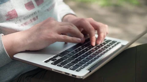 A young man works remotely at a computer in the fresh air. Stock Footage 241178042
