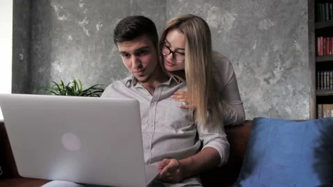 A young man works remotely on his laptop, his girlfriend decided to cheer him Stock Footage 198876895