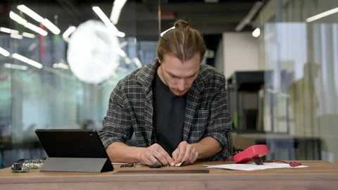 Young Man In The Workshop Is Engaged In Soldering. Chips And Devices On The Stock Footage 154707801
