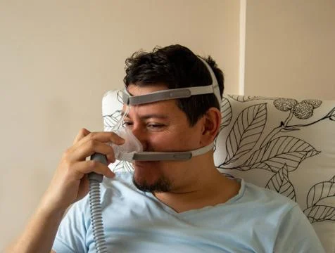 Young man is worried about using nasal CPAP mask Stock Photos