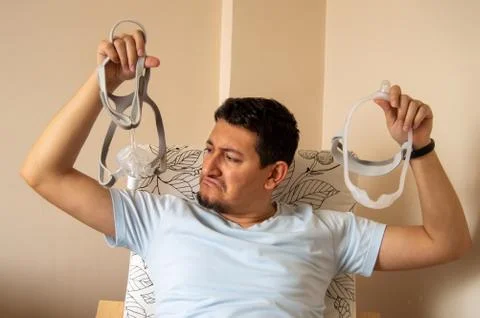 Young man is worried about using nasal CPAP mask Stock Photos