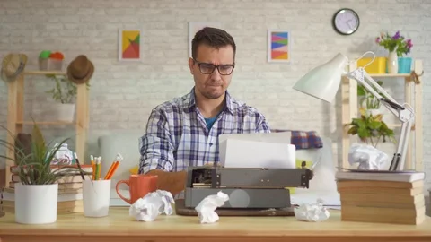 Young man writer prints without inspiration on a typewriter and throwing the Stock Footage 104162202